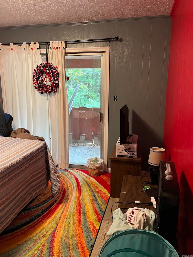 bedroom with a textured ceiling, wood walls, and hardwood / wood-style floors