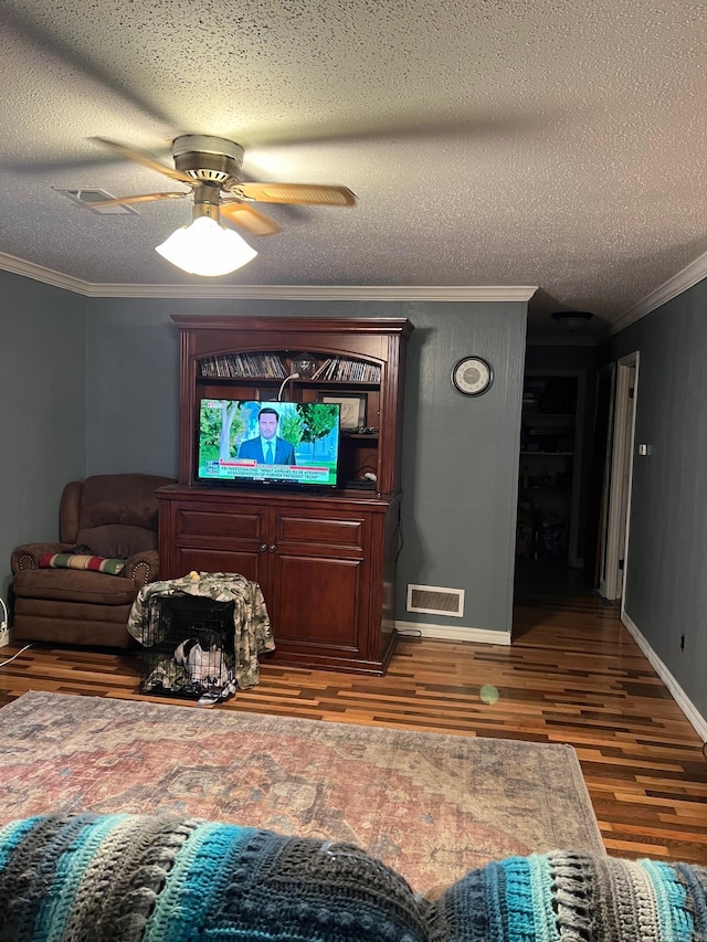 living room with crown molding, ceiling fan, hardwood / wood-style flooring, and a textured ceiling