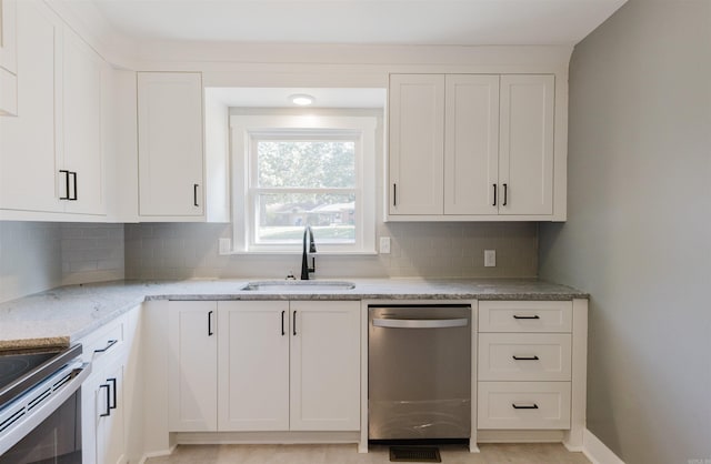 kitchen featuring sink, white cabinets, decorative backsplash, appliances with stainless steel finishes, and light stone countertops