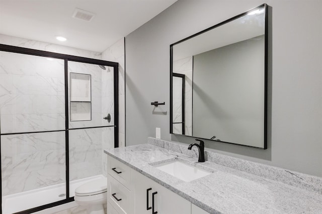 bathroom with walk in shower, vanity, and toilet