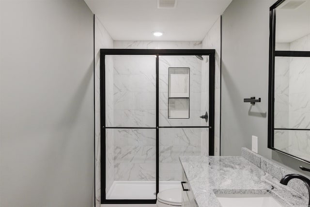 bathroom featuring walk in shower, vanity, and toilet