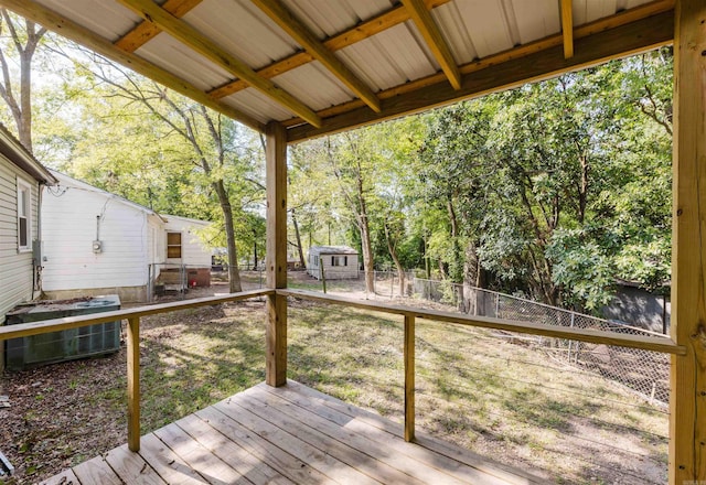 deck with a lawn, a shed, and central AC