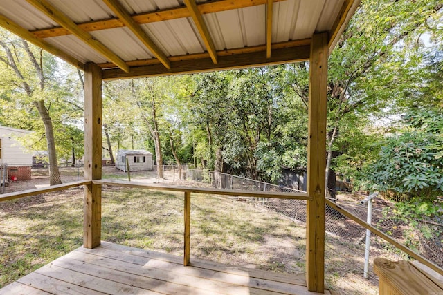 wooden deck with a storage unit and a lawn