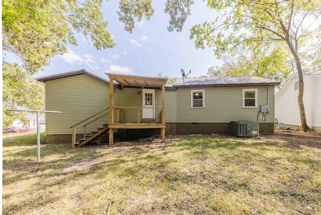 back of property with a lawn and central air condition unit