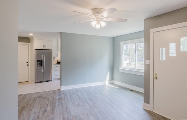 foyer entrance with ceiling fan and light hardwood / wood-style floors