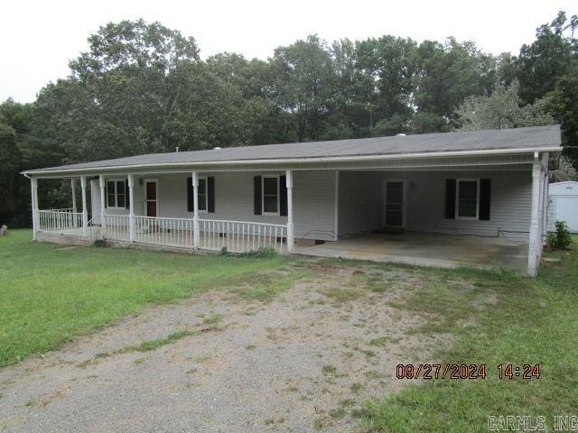 view of front of house featuring a front yard, a porch, and a carport