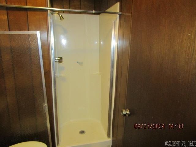 bathroom featuring walk in shower and toilet