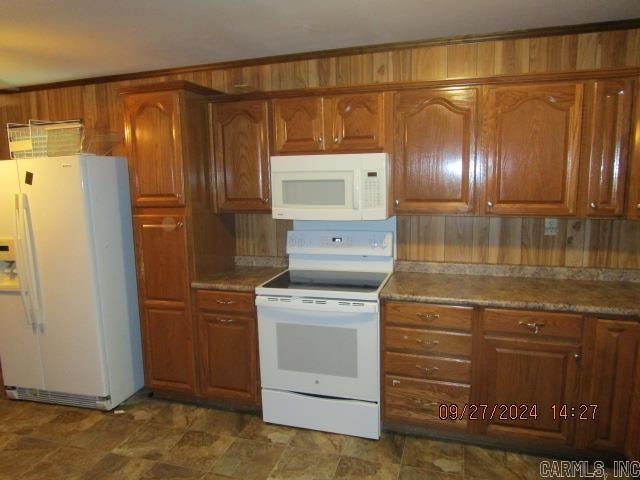 kitchen with crown molding and white appliances