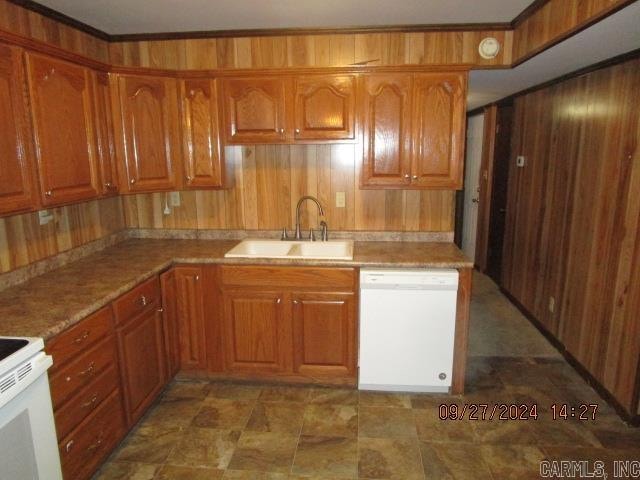 kitchen with wooden walls, sink, and white appliances