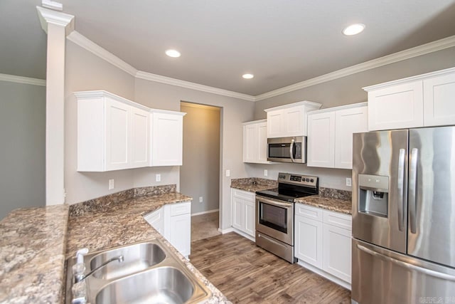 kitchen featuring sink, white cabinetry, light hardwood / wood-style flooring, stainless steel appliances, and ornamental molding