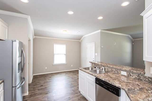 kitchen with dark stone counters, dark hardwood / wood-style floors, white cabinetry, stainless steel appliances, and ornamental molding