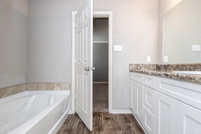 bathroom featuring wood-type flooring, vanity, and a bathtub