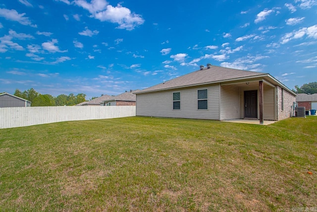 back of house featuring a lawn and a patio