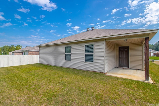 rear view of house with a yard and a patio