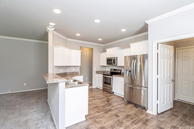 kitchen featuring light stone counters, white cabinets, stainless steel appliances, and kitchen peninsula