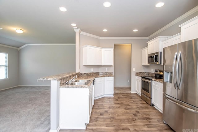 kitchen featuring light carpet, stainless steel appliances, white cabinetry, and sink