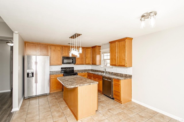 kitchen featuring sink, decorative light fixtures, black appliances, a center island, and decorative backsplash