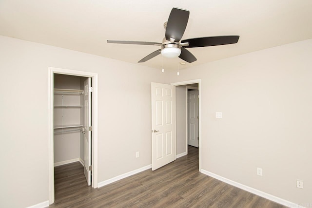 unfurnished bedroom featuring dark hardwood / wood-style flooring, ceiling fan, and a closet