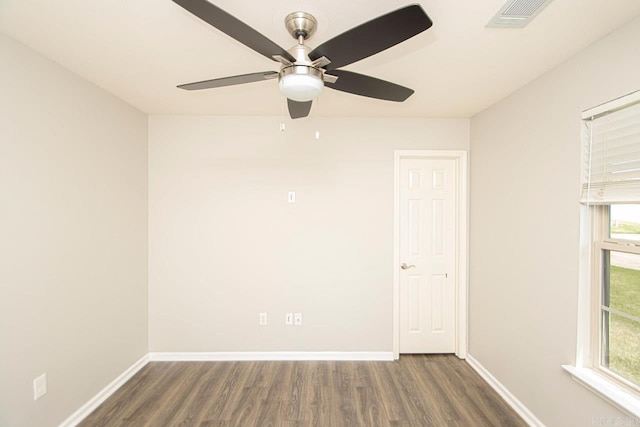 spare room with a wealth of natural light, ceiling fan, and dark wood-type flooring