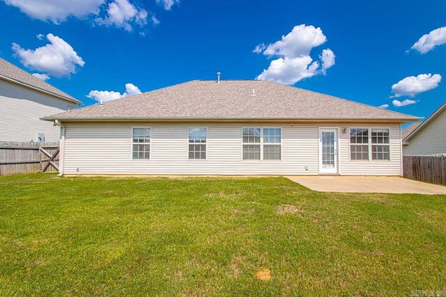 rear view of property featuring a patio and a lawn