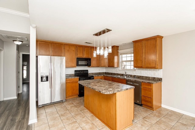 kitchen with pendant lighting, tasteful backsplash, a breakfast bar area, a kitchen island, and black appliances