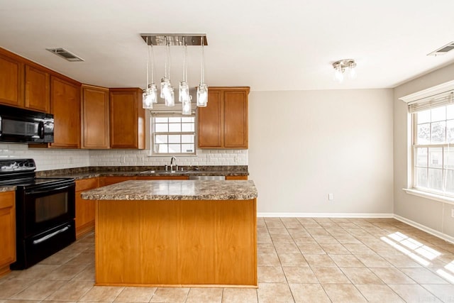 kitchen featuring decorative backsplash, black appliances, hanging light fixtures, and a kitchen island