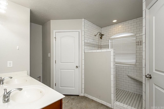 bathroom with vanity and tiled shower