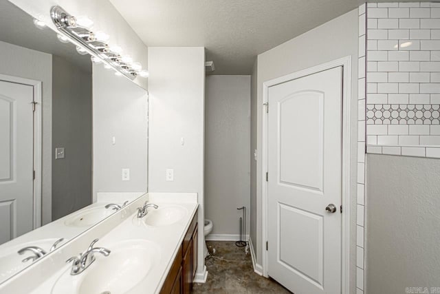 bathroom featuring a textured ceiling, vanity, and toilet