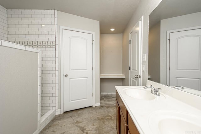 bathroom with vanity and tiled shower