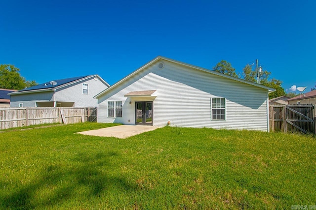 back of house with a lawn and a patio