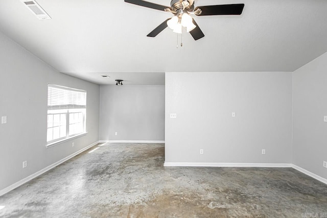 unfurnished room with ceiling fan and concrete floors