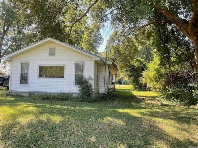 view of side of home with a yard