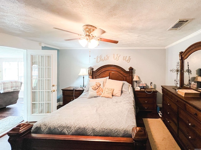 bedroom with ceiling fan, a textured ceiling, and crown molding