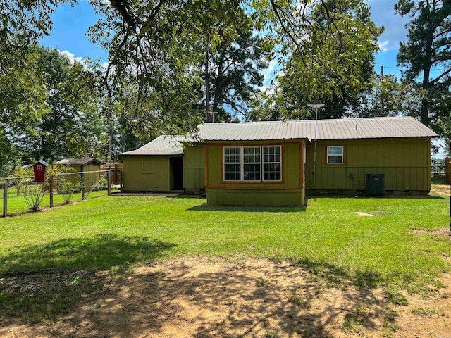 back of house with a lawn and central air condition unit