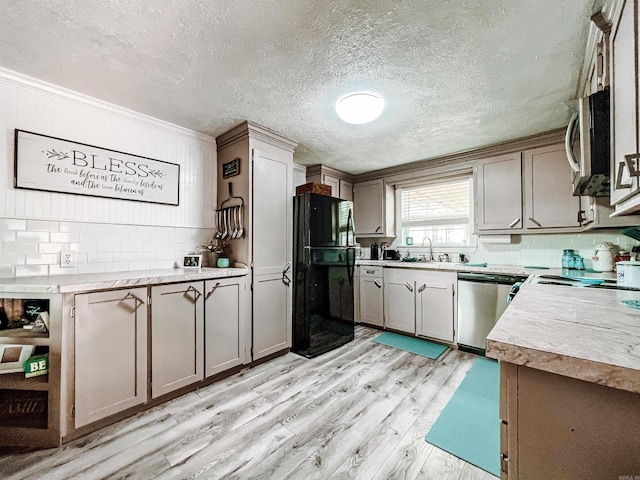 kitchen featuring sink, stainless steel appliances, crown molding, light hardwood / wood-style floors, and decorative backsplash