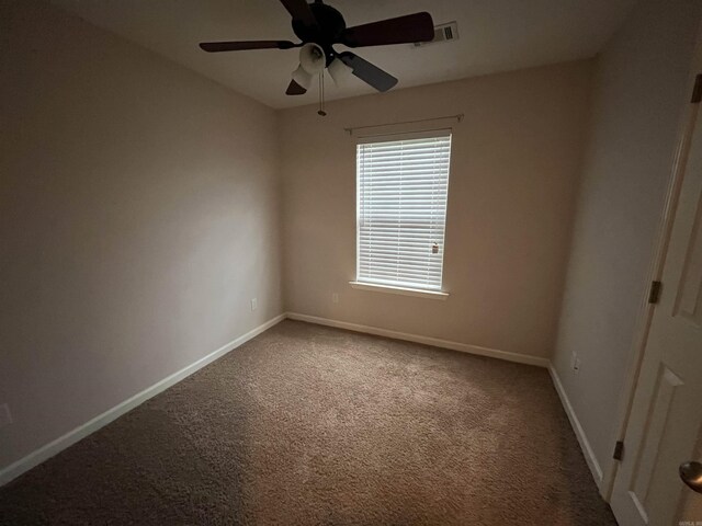 spare room featuring ceiling fan, a textured ceiling, and dark carpet