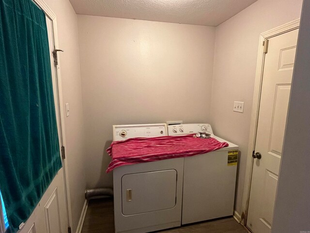 laundry room featuring a textured ceiling and washing machine and dryer