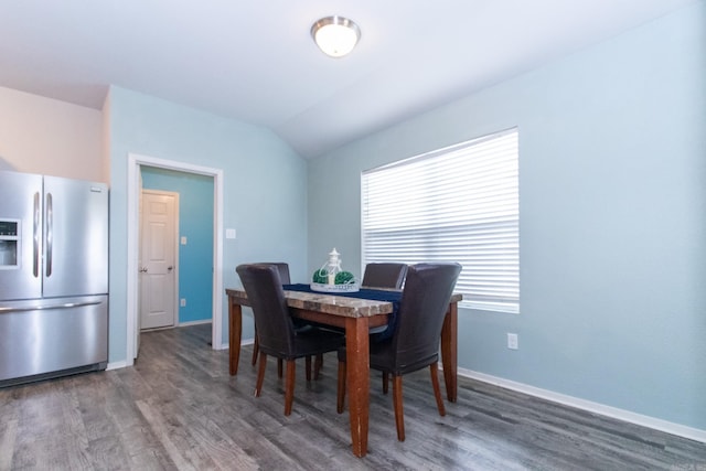 dining space with dark hardwood / wood-style floors and vaulted ceiling