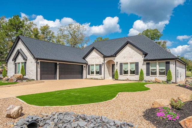 french provincial home featuring a front yard and a garage