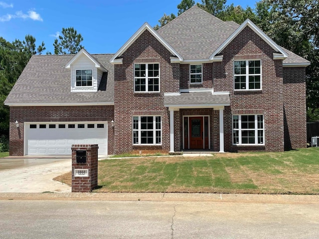 view of front of home featuring a garage, central air condition unit, and a front yard