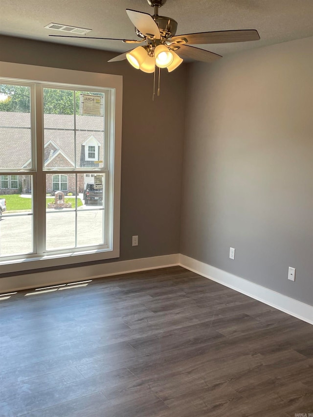 empty room featuring a textured ceiling, dark hardwood / wood-style floors, and ceiling fan