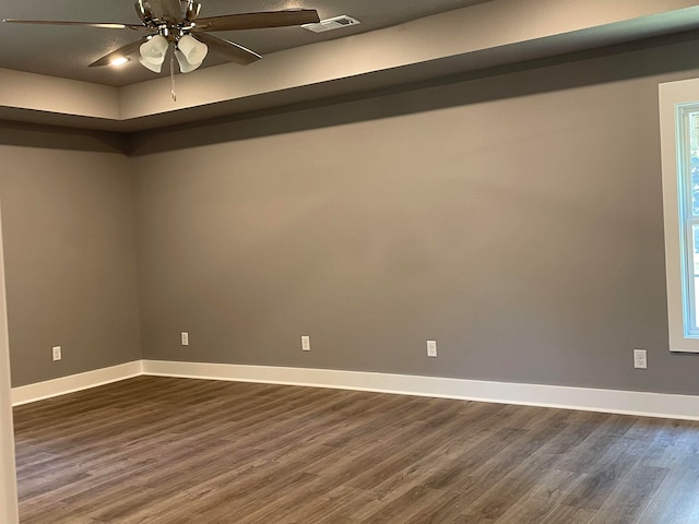 spare room with dark wood-type flooring and ceiling fan