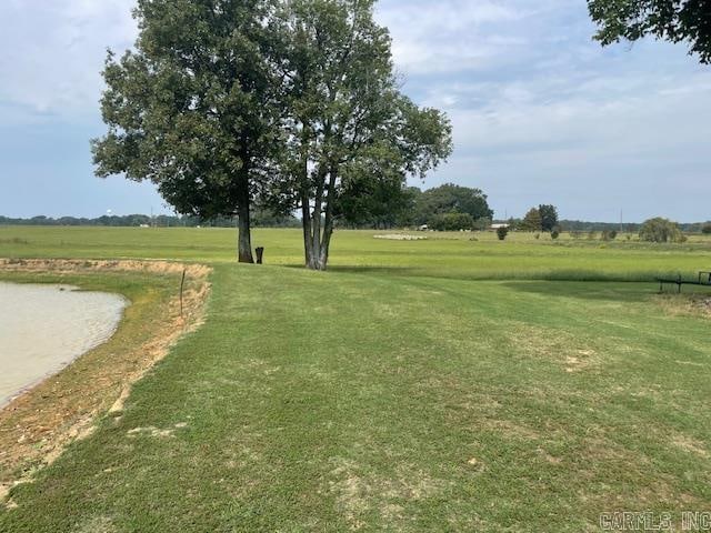 surrounding community with a rural view and a yard