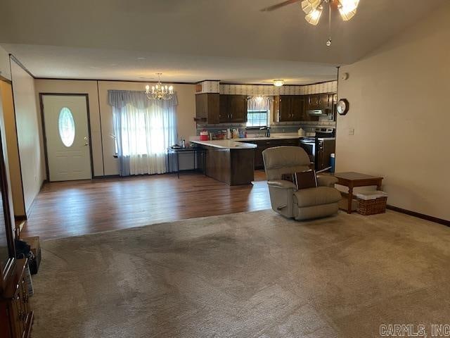 kitchen with a kitchen breakfast bar, stainless steel electric stove, dark brown cabinets, a center island, and dark hardwood / wood-style floors