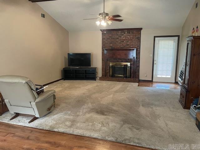 unfurnished living room with light wood-type flooring, lofted ceiling, ceiling fan, and a brick fireplace