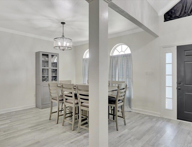 dining area featuring a notable chandelier, light hardwood / wood-style flooring, and crown molding