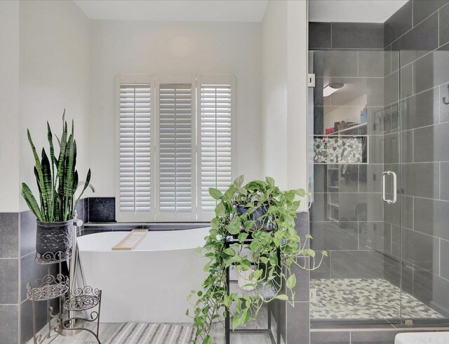 bathroom featuring separate shower and tub