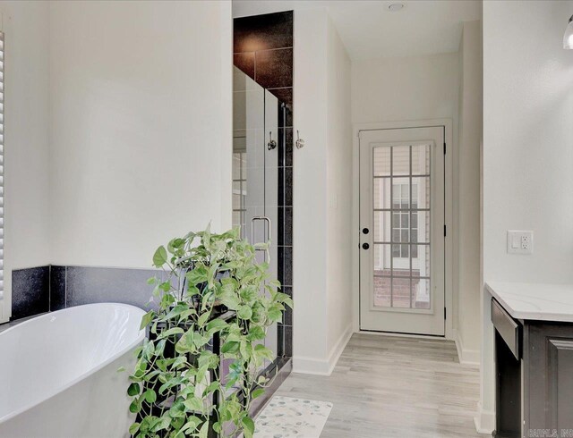 bathroom featuring hardwood / wood-style floors and separate shower and tub