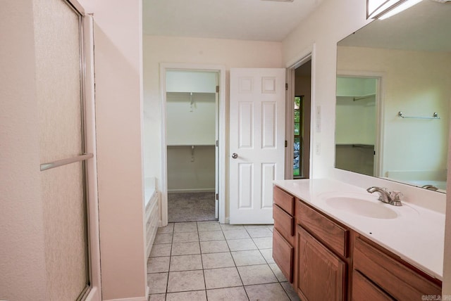 bathroom featuring tile patterned flooring, plus walk in shower, and vanity