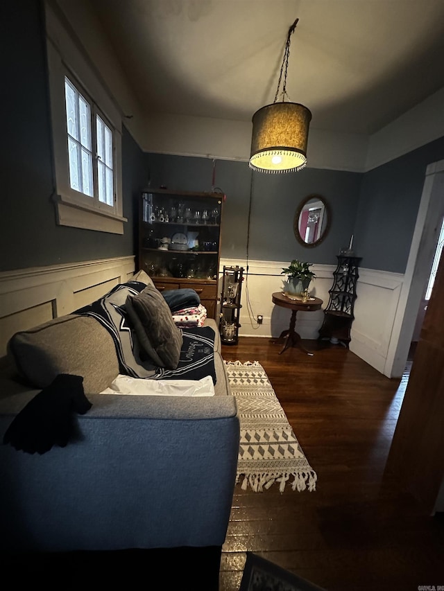 living area with a wainscoted wall and dark wood finished floors